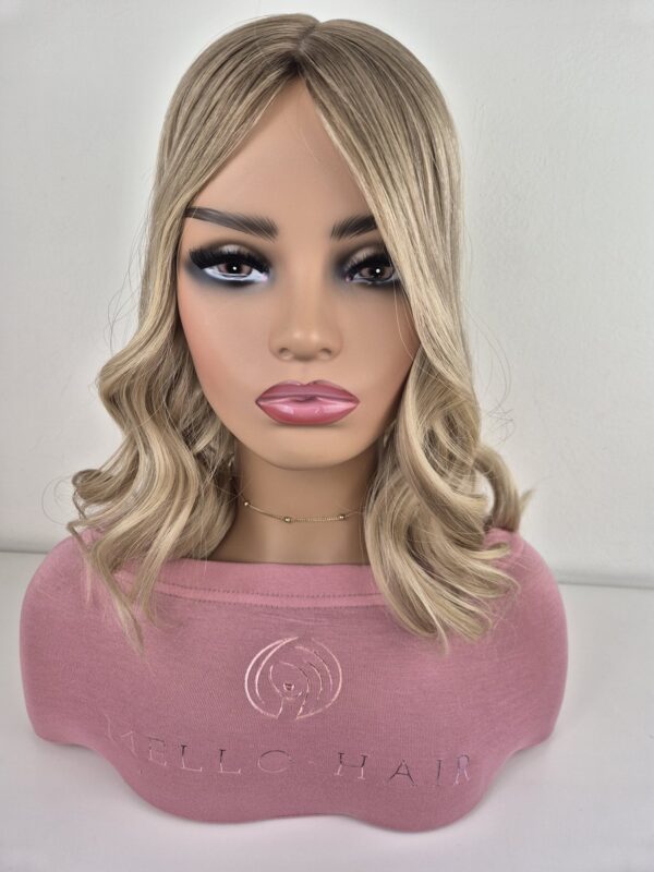 Clara silk top hair topper 16 inches in length. warm to neutral blonde. Displayed on a mannequin