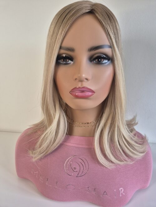 Clara silk top hair topper 16 inches in length. warm to neutral blonde. Displayed on a mannequin