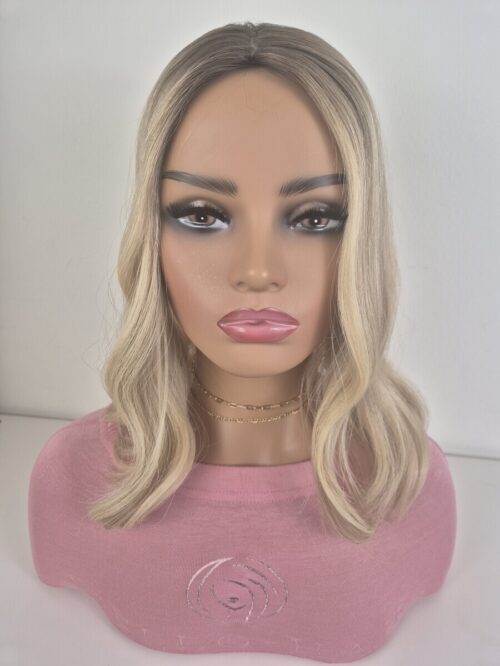 Clara silk top hair topper 16 inches in length. warm to neutral blonde with a level 7 root Displayed on a mannequin