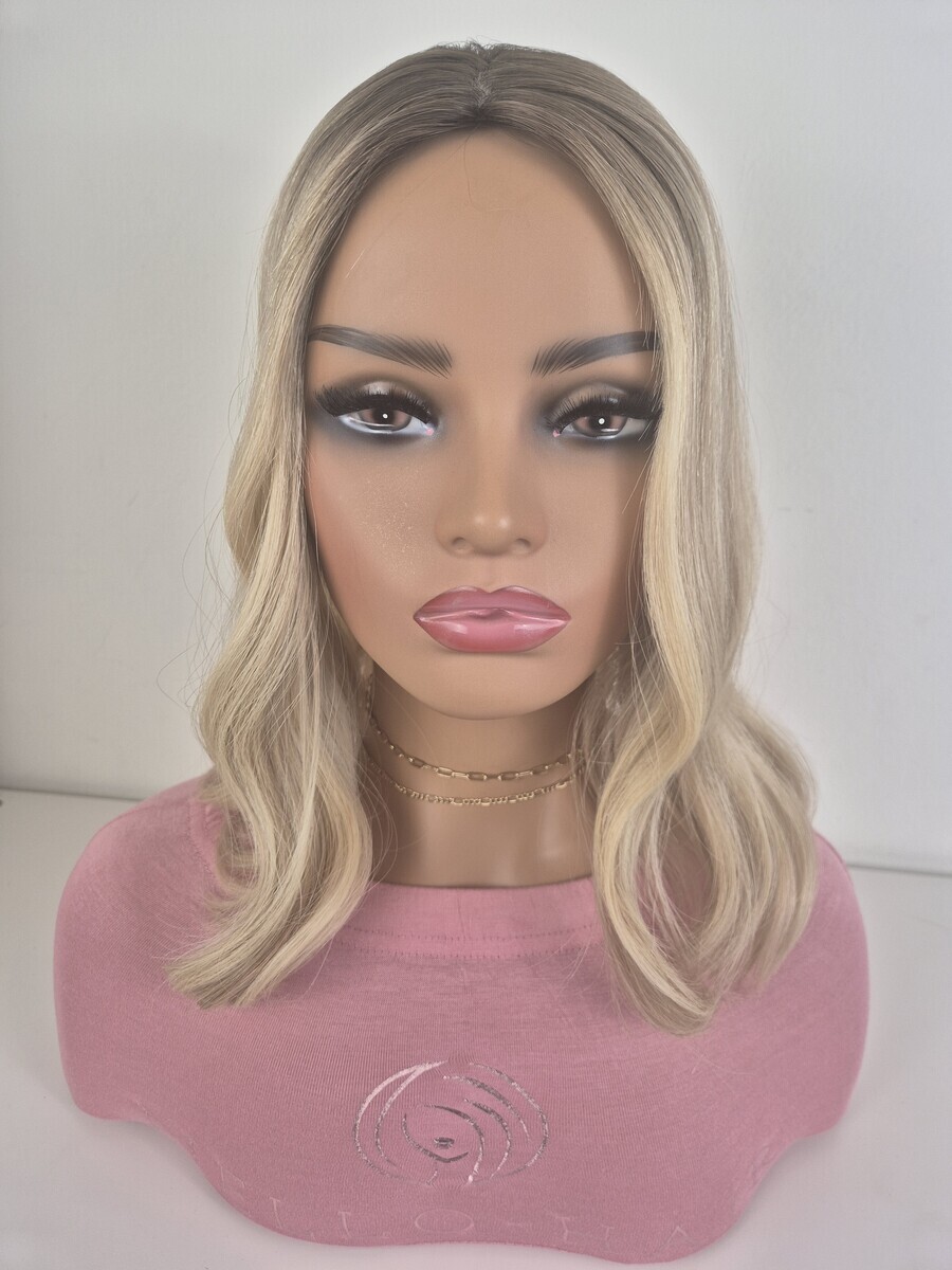 Clara silk top hair topper 16 inches in length. warm to neutral blonde with a level 7 root Displayed on a mannequin