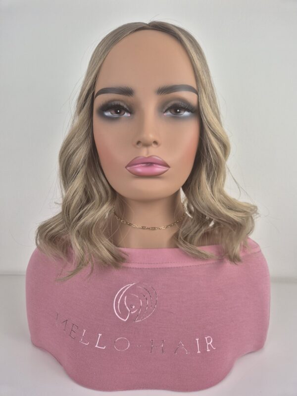 Florence Handtied hair topper 15 inches in length style with a curl in a beige blonde displayed on a Mannequin