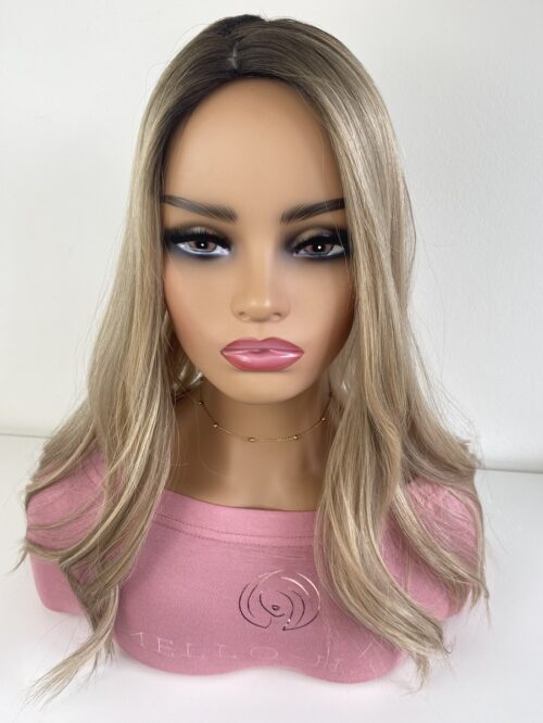 Sian silk top hair topper 18 inches in length blonde with a darker root displayed on a mannequin