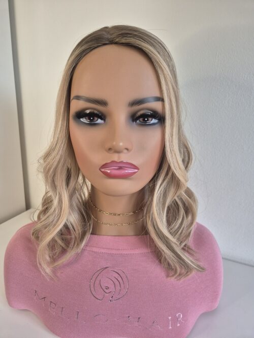 Lacie silk top hair topper 16 inches in length blonde with a darker root displayed on a mannequin