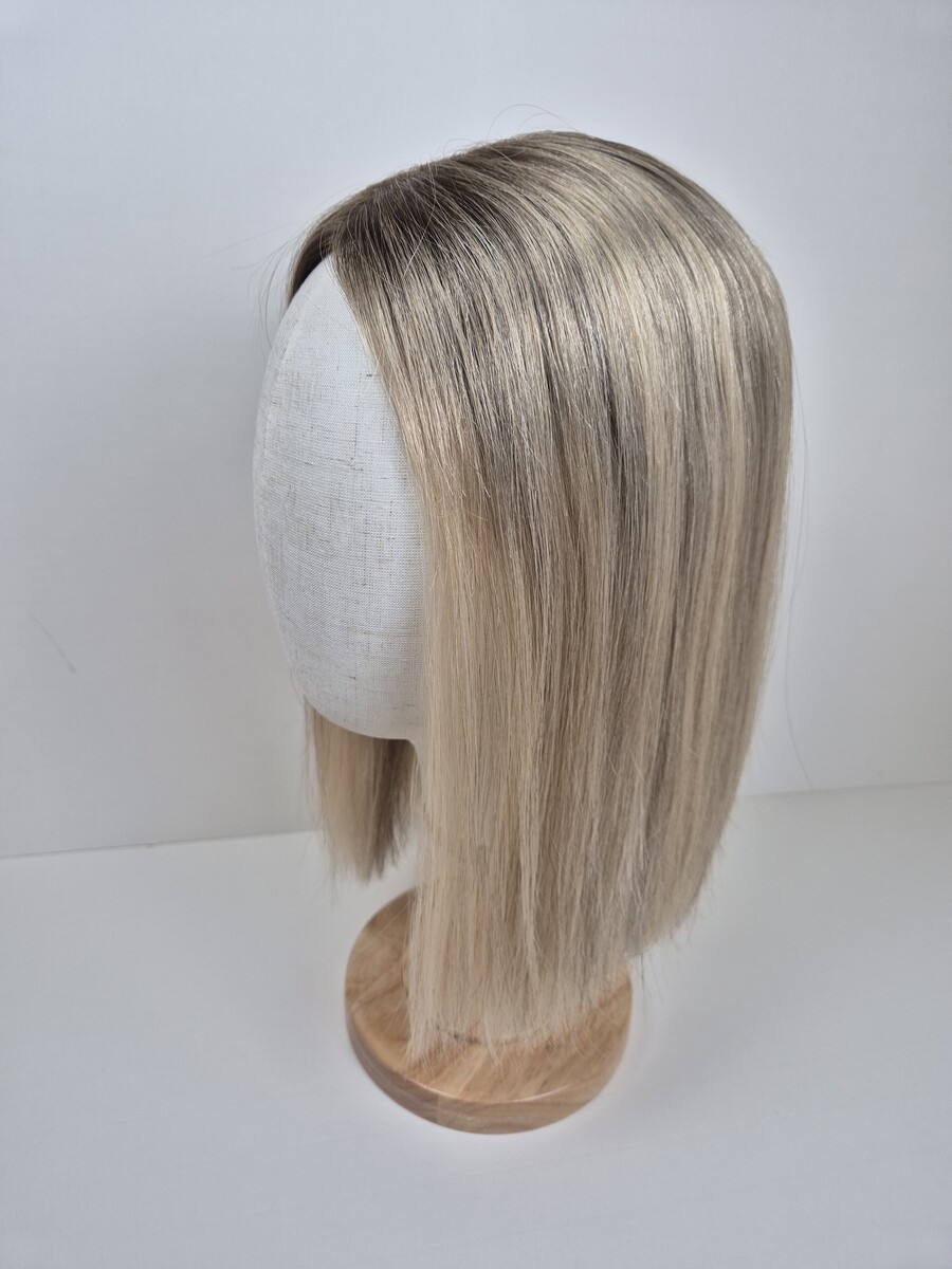 Betsy lace topper 14 inch length medium blonde with ashy undertones and root. Displayed on a mannequin