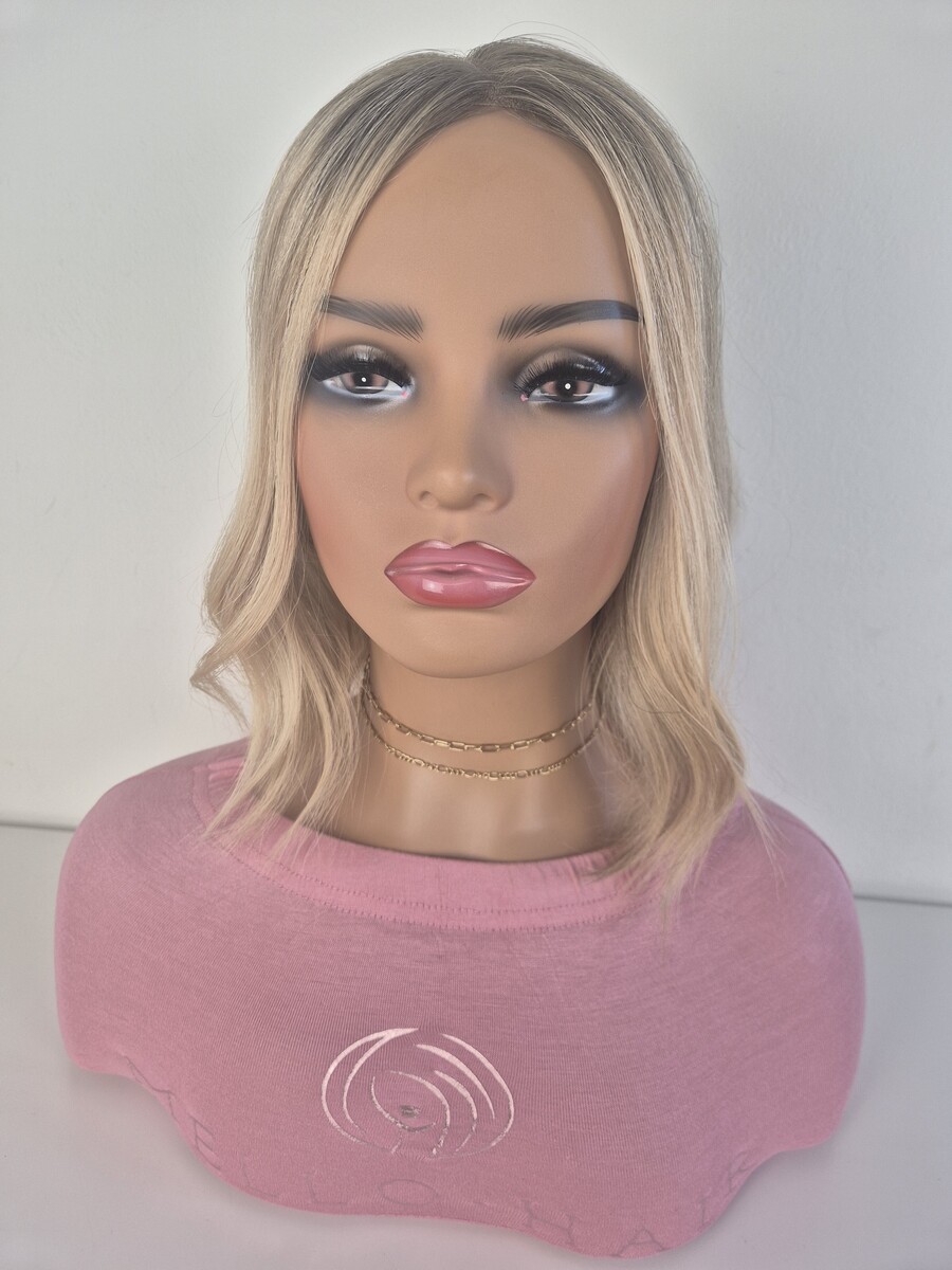 Kelly Lace Topper 14-inch creamy blonde styled with a wave displayed on a mannequin