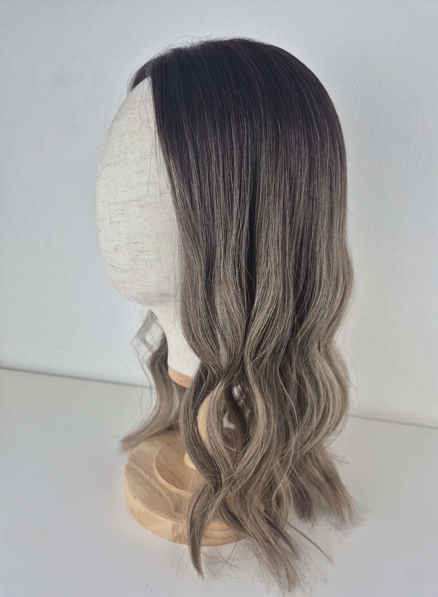 Lydia lace topper 18 inches medium brown root melting into a lighter ash beige brown. Displayed on a mannequin styled waved