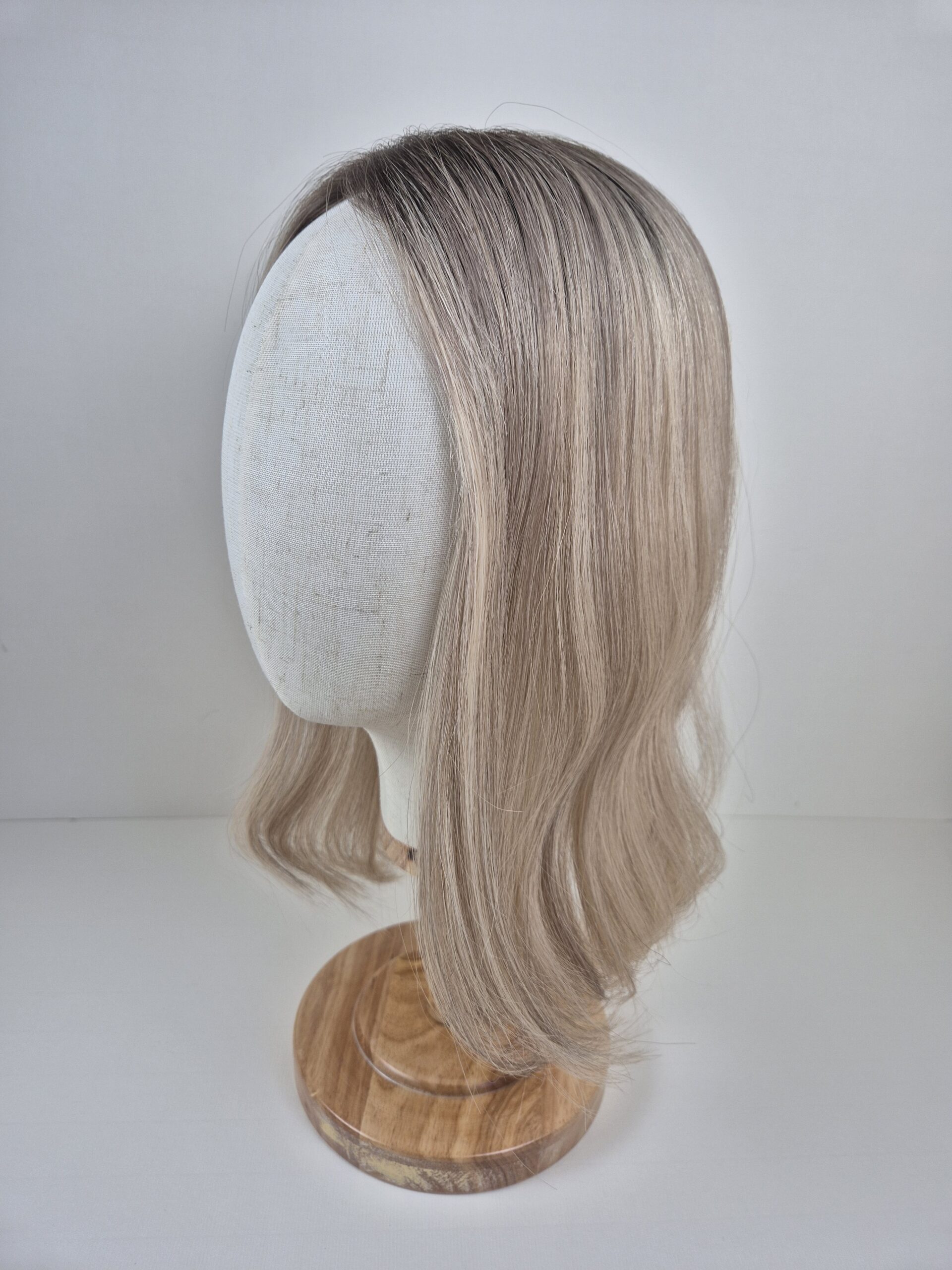 Stephanie Little Lace medium blonde ashy undertones and root styled wavy displayed on a mannequin