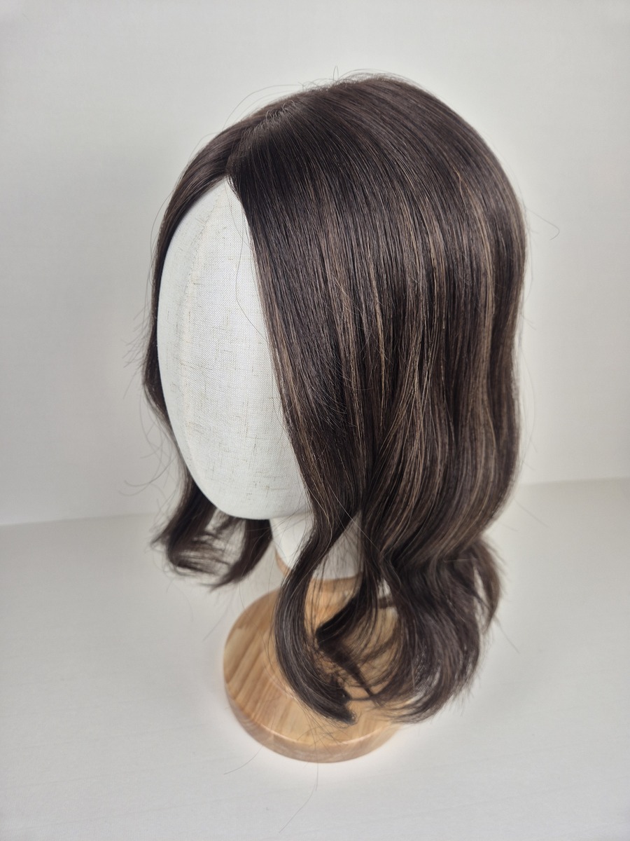 Amber Ribbon Silk topper 16 inches in length dark chocolate brown with soft caramel highlights styled wavy displayed on a Mannequin