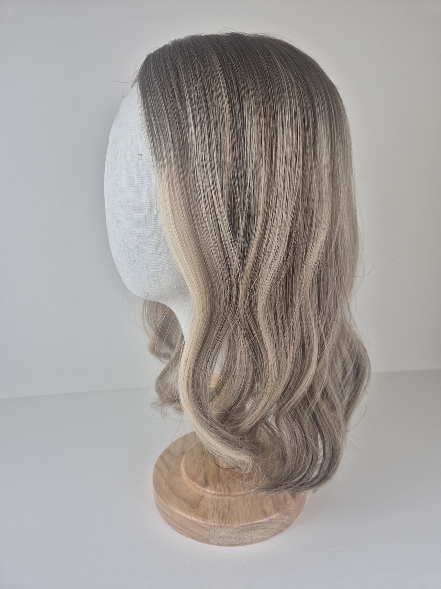 Ava 14 inch length beige blonde with a ash brown root 7x7 cap styled with a wave displayed on a mannequin head