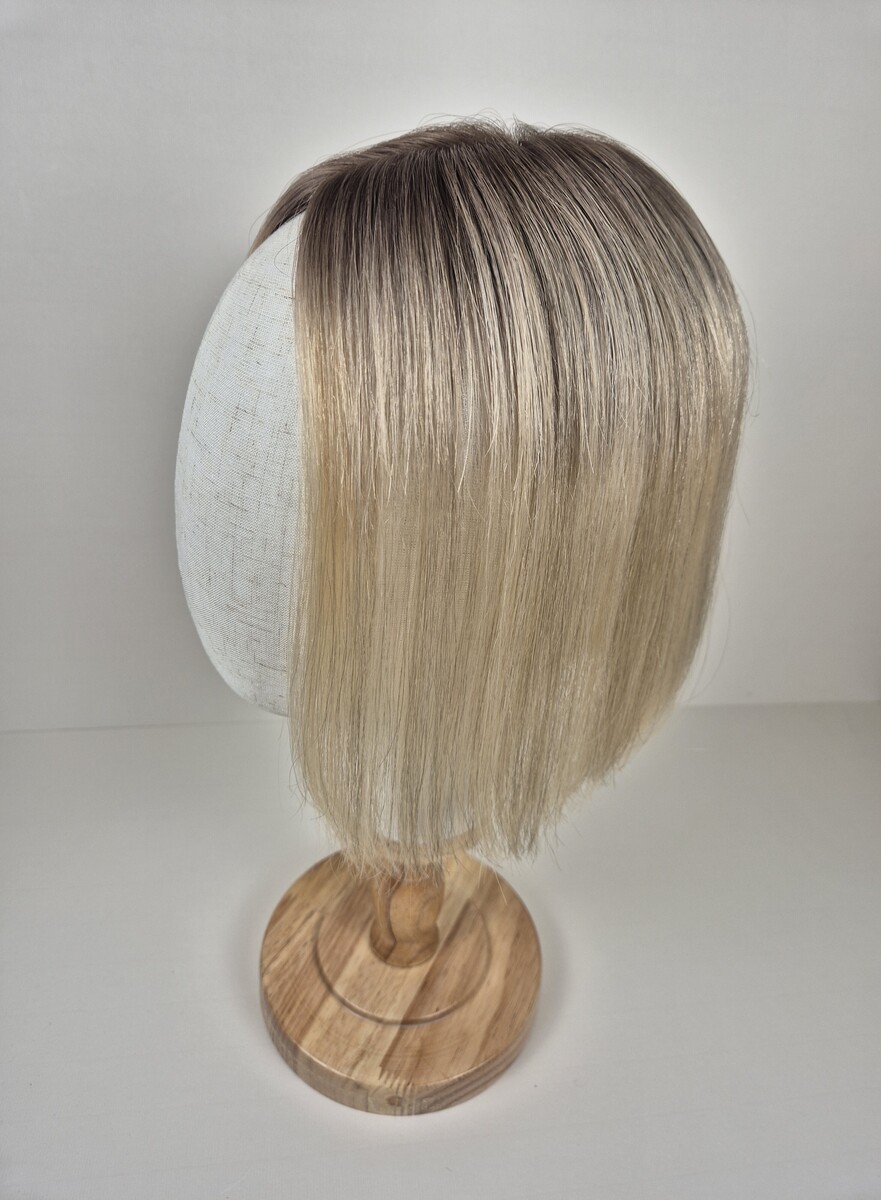 Cora Tiny Topper 11 inch length a creamy blonde with a soft ash root. styled straight and displayed on a mannequin