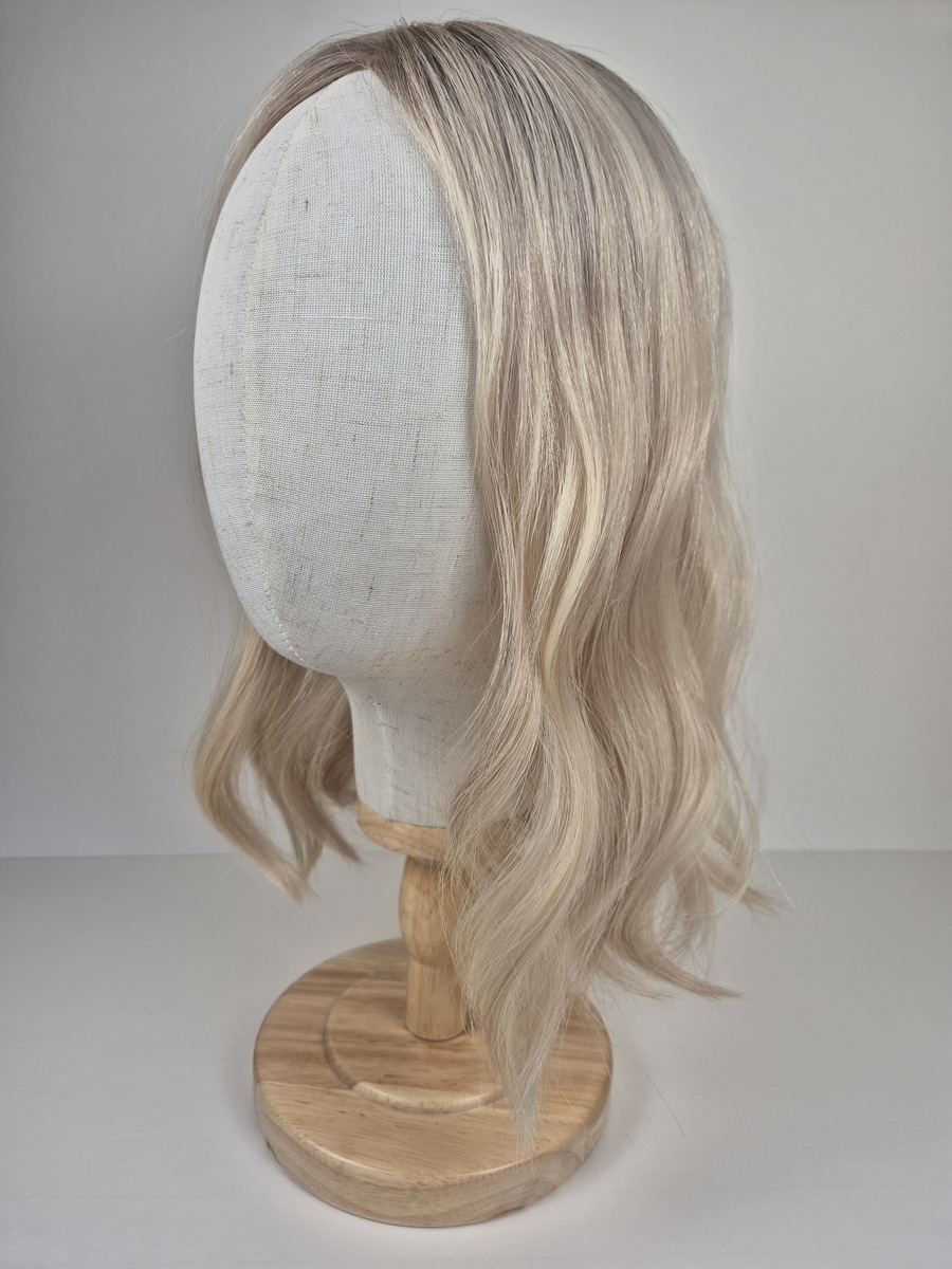 Diva Ribbon Silk l topper 16 inches in length cool light blonde with a subtle root shadow styled wavy displayed on a Mannequin