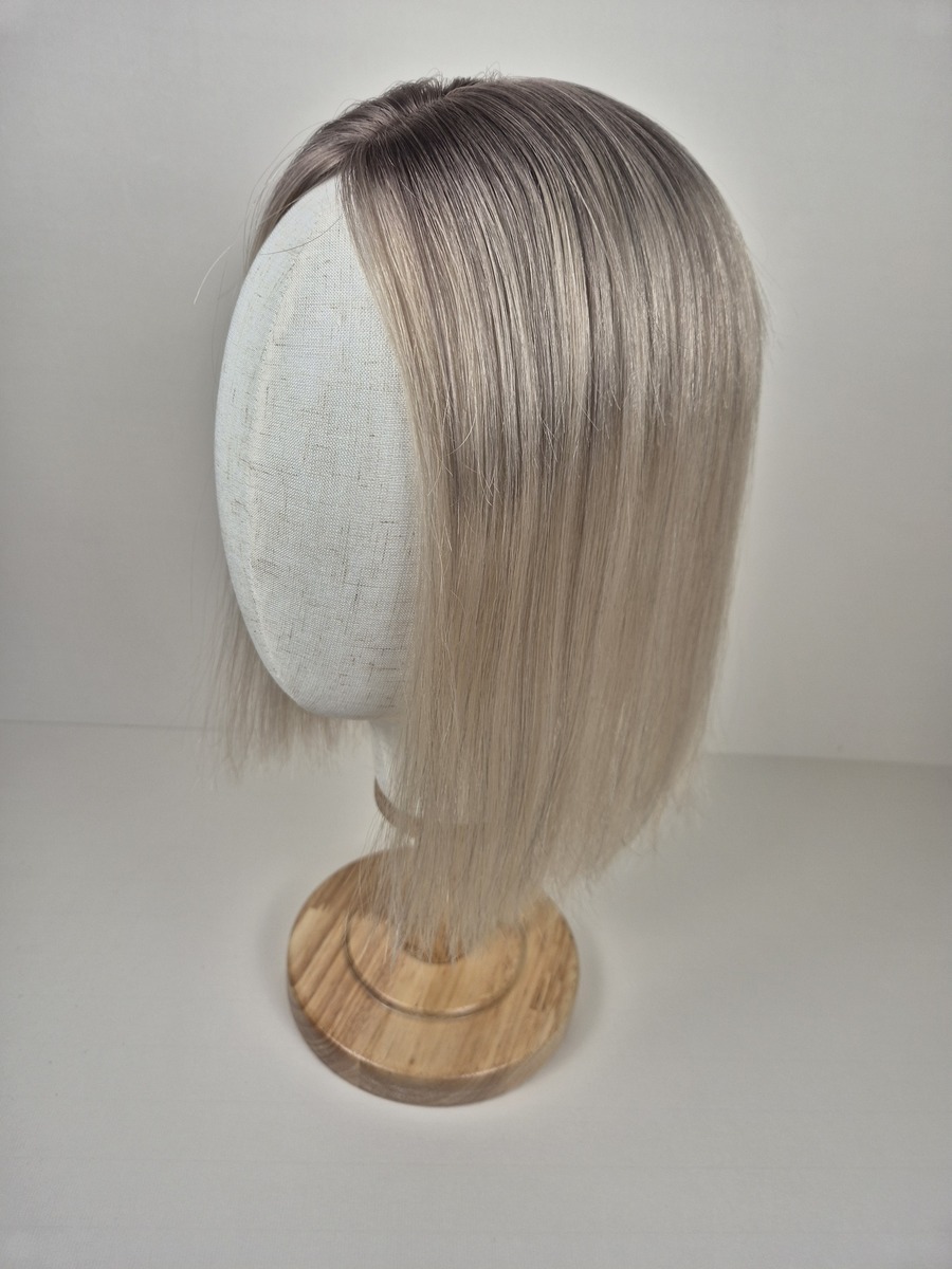 Lena Tiny Topper a soft light neutral blonde with a smoky ash root 12 inches displayed on a mannequin styled straight
