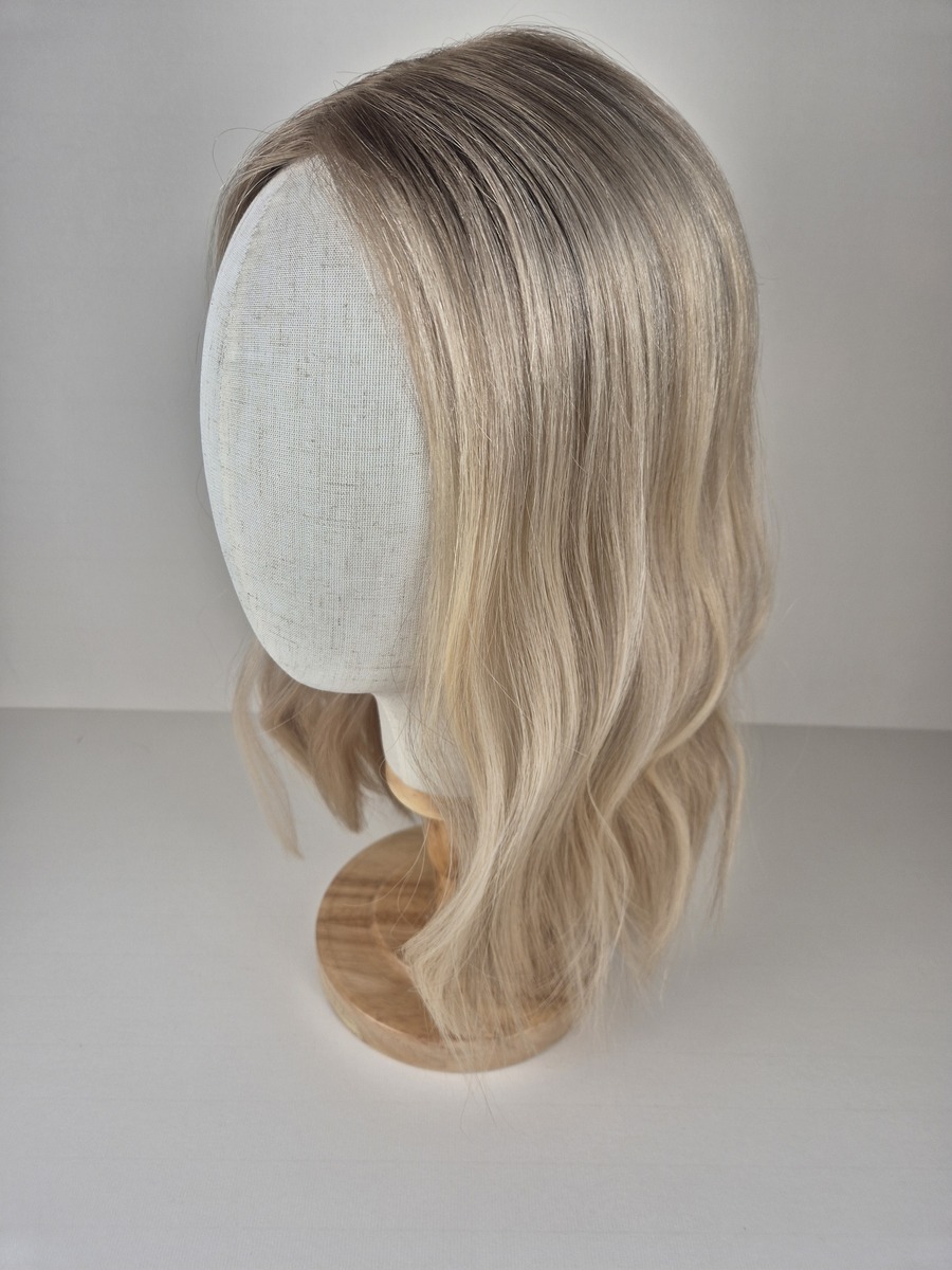 Claire Ribbon Silk l topper 16 inches in length light blonde with a beige root styled wavy displayed on a Mannequin